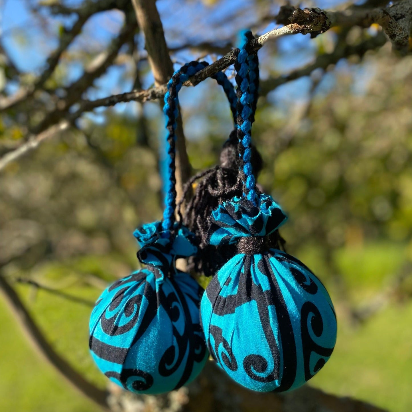 Māori Poi Turquoise Koru Rakau with blue & black Braided Cord